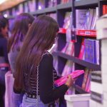 A woman browses books on a shelf at the Guadalajara International Book Fair