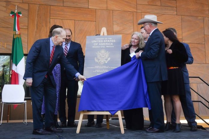 U.S. Ambassador to Mexico Ken Salazar and U.S. Bureau of Overseas Building Operations Director William H. Moser together pull a blue cloth off to reveal a metal plaque bearing the name 
