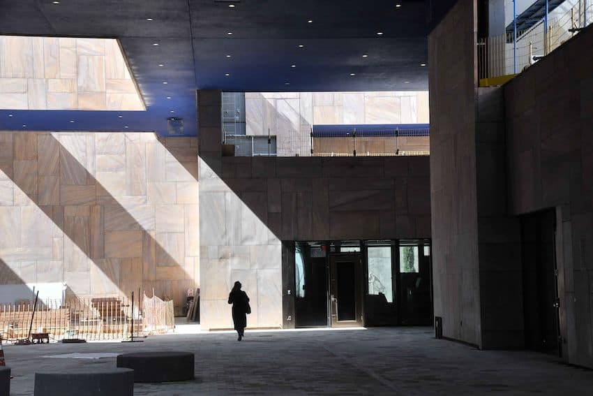 Courtyard at the site of the not yet opened US Embassy building in Mexico City. A woman in silhouette walks in the courtyard in the distance.